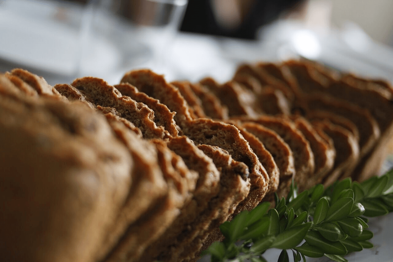 liced whole-grain bread arranged neatly with a sprig of green leaves in the foreground."